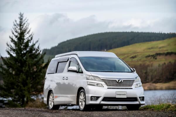Toyota Alphard Connect II Campervan in mountain area with roof up next to loch roof down