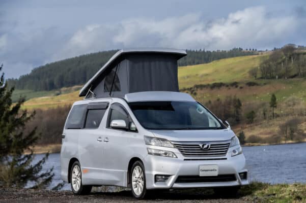 Front nearside view of silver Toyota Alphard Connect II Campervan next to loch