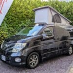 Black Nissan Elgrand Velocity with roof up forecourt with flag