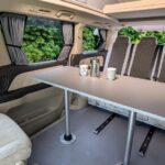 Toyota Alphard Hybrid Eco Explorer ZME white living area with table and bed up