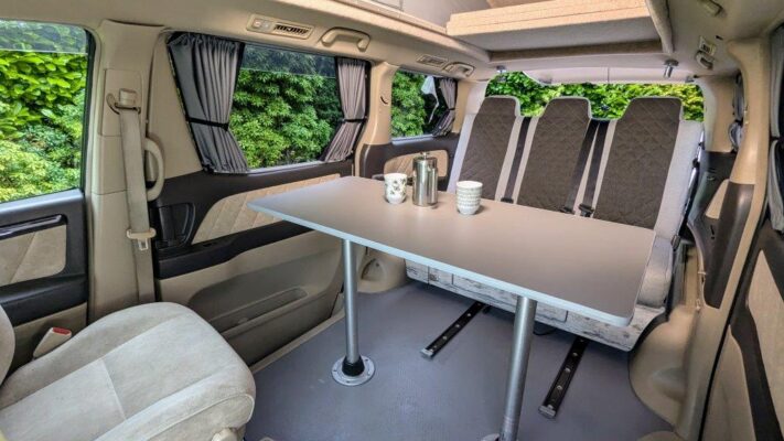 Toyota Alphard Hybrid Eco Explorer ZME white living area with table and bed up